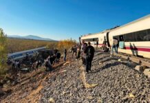 Pasajeros caminan junto a la vía y un vagón volcado en el terraplén tras el accidente de tren en Urda (Toledo)
